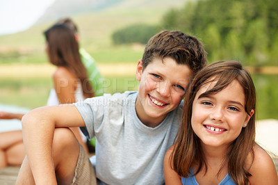 Buy stock photo Children, portrait and smile on jetty for vacation with countryside, bonding and relax in nature together. Family, brother and sister with dock outdoor for holiday, summer trip and travel by lake