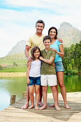 Buy stock photo Portrait, happy and family on pier by lake for travel, together or bonding with summer vacation in nature. People, parents and kids with smile, holiday or break with relax by river for connection