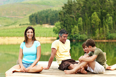Buy stock photo Woman, travel and family on pier by lake, together or bonding with summer vacation in nature. Mom, dad and children for holiday break, relax and happy portrait outdoor for fresh air by river