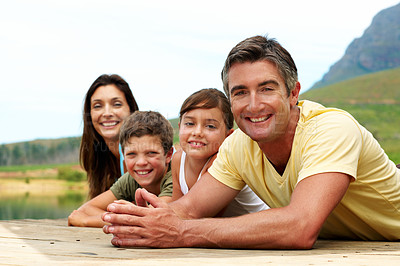 Buy stock photo Portrait, happy and family in nature for travel, together or bonding with summer vacation. People, parents and kids with smile outdoor, holiday or break with relax on pier for connection and getaway