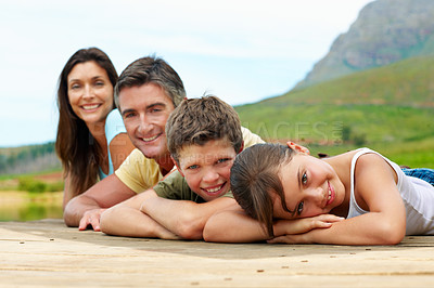 Buy stock photo Portrait, happy and family outdoor for travel, together or bonding with summer vacation in nature. People, parents and kids with smile, holiday or break with relax on pier for connection and getaway