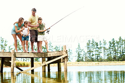 Buy stock photo Happy, parents and kids by lake for fishing, summer vacation and bonding on weekend getaway. Family, space and pier with mom, dad and children for fun, adventure and learning to catch fish together