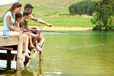 Buy stock photo Happy family, pier and fishing at lake on vacation, teaching and pointing for connection together. Parents, children and rod by water outdoor for relax, learning and bonding on holiday with space