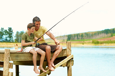 Buy stock photo Father, child and fishing at lake pier on vacation, teaching and pointing for connection together. Parent, boy and rod by water outdoor for relax, learning and bonding on holiday with happiness