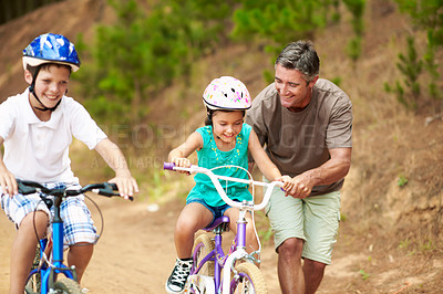 Buy stock photo Support, dad or children outdoor with bicycle, bonding together and guidance in summer hobby. Smile, cycling and family with helping, teaching moment and parent connection for childhood development.