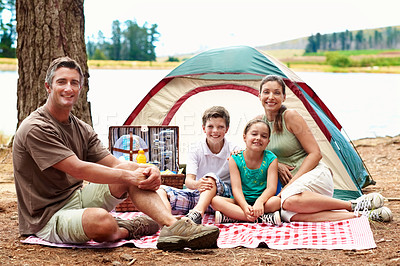 Buy stock photo Family, portrait and camping outdoor by a lake with a tent, happiness and holiday in summer. Man, woman and children together on picnic blanket in nature for bonding, vacation and relax by river