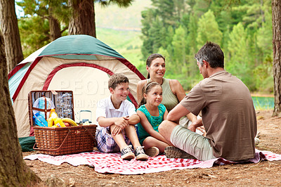 Buy stock photo Parents, kids and camping in nature with tent, picnic basket and bonding together for summer holiday. Happy family, mother and father outdoor at campsite with children, relax or countryside vacation.