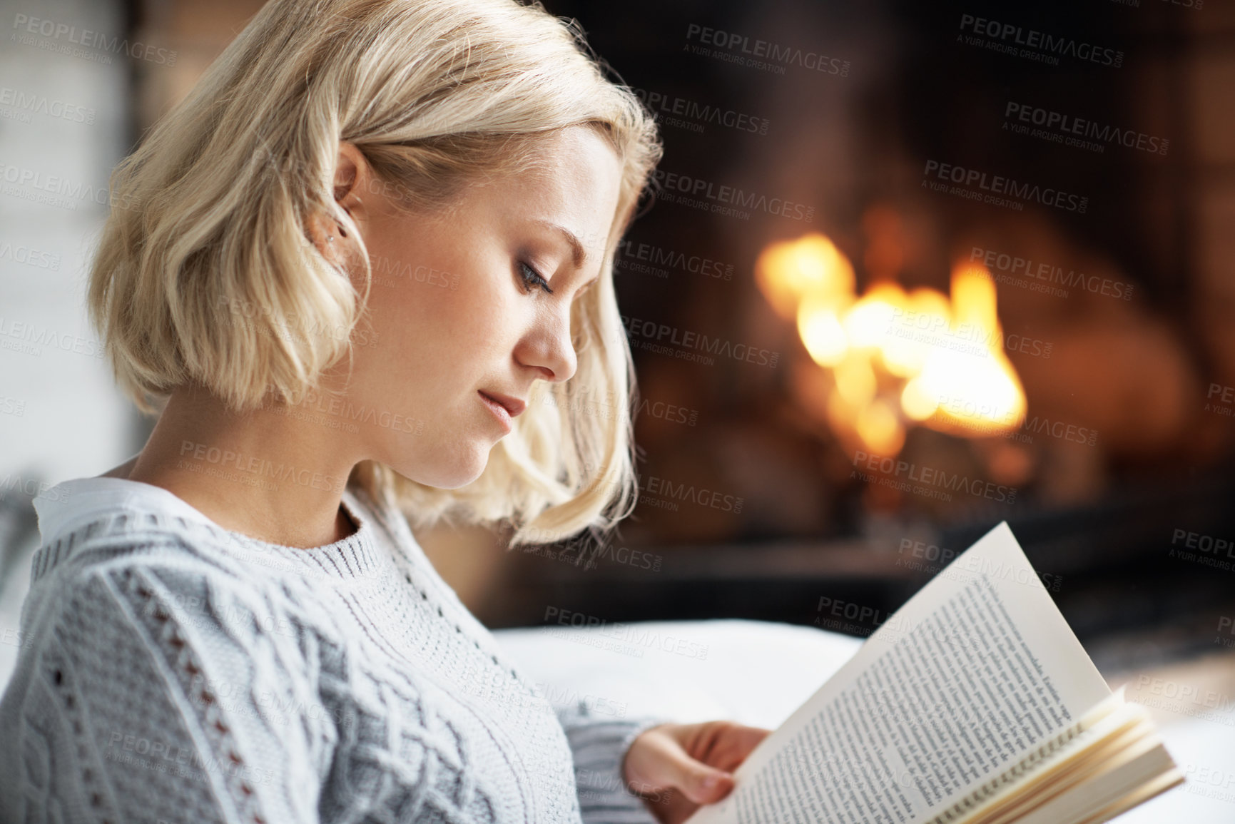 Buy stock photo Reading, book and woman in home by fireplace for comfort, hobby and relax with literature. Calm, house and person with story, novel and fiction for information, knowledge and me time on weekend