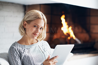Buy stock photo A head and shoulders shot of a pretty young woman using a digital tablet at home                             
