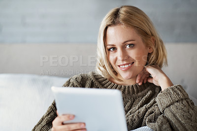 Buy stock photo A portrait of a beautiful young woman using a digital tablet in her home