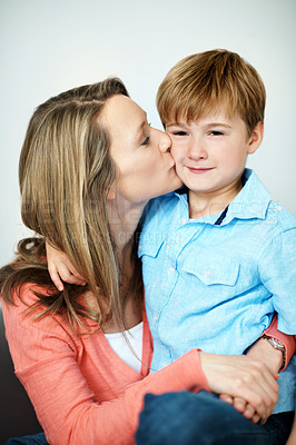 Buy stock photo Mother, child and kiss in living room with hug, family wellness and bonding together on weekend break. Portrait, woman and son embrace in home with affection, connection and caring parent for kid.