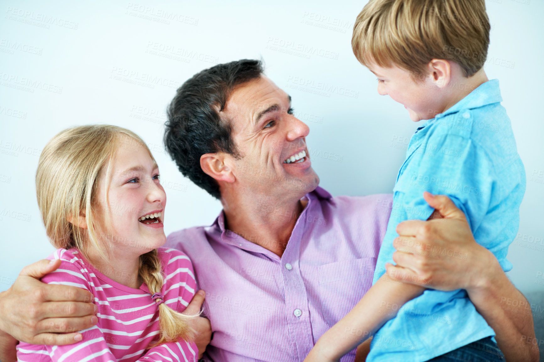 Buy stock photo Laughing, father and hug children for love, care and bonding together with joke in studio. Siblings, funny parent and embrace with dad for support, trust and family connection on white background