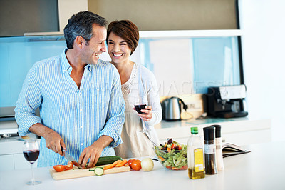 Buy stock photo Laugh, happy couple and cooking with red wine, chopping board and vegetables with love in home. Mature man, woman and meal prep at kitchen with alcohol for funny joke, healthy cucumber and vegan diet