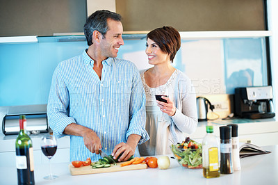 Buy stock photo Love, happy couple and cooking with red wine, cut vegetables and organic nutrition in home. Mature man, woman or meal prep with alcohol glass at kitchen, healthy cucumber or care with vegetarian diet