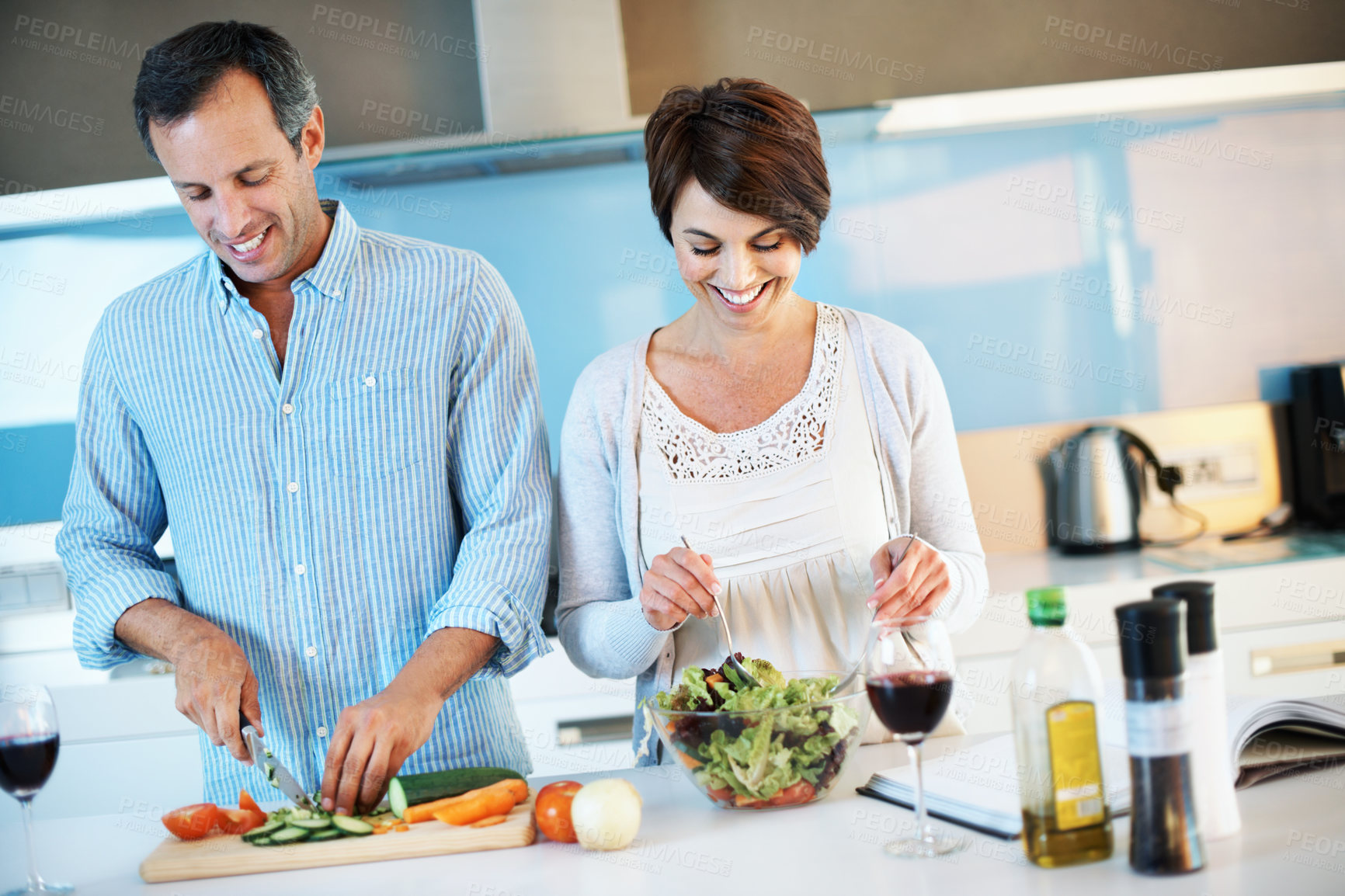Buy stock photo Help, happy couple and cooking with vegetables at kitchen to mix salad, organic food and wine. Mature man, woman and meal prep in home, slice cucumber and vegetarian diet for nutrition with love