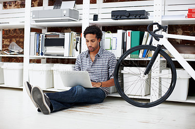 Buy stock photo Laptop, bicycle and black man on floor in office for copywriting, online article and story draft. Creative, startup and person on computer for research, website blog and report with bike in workplace