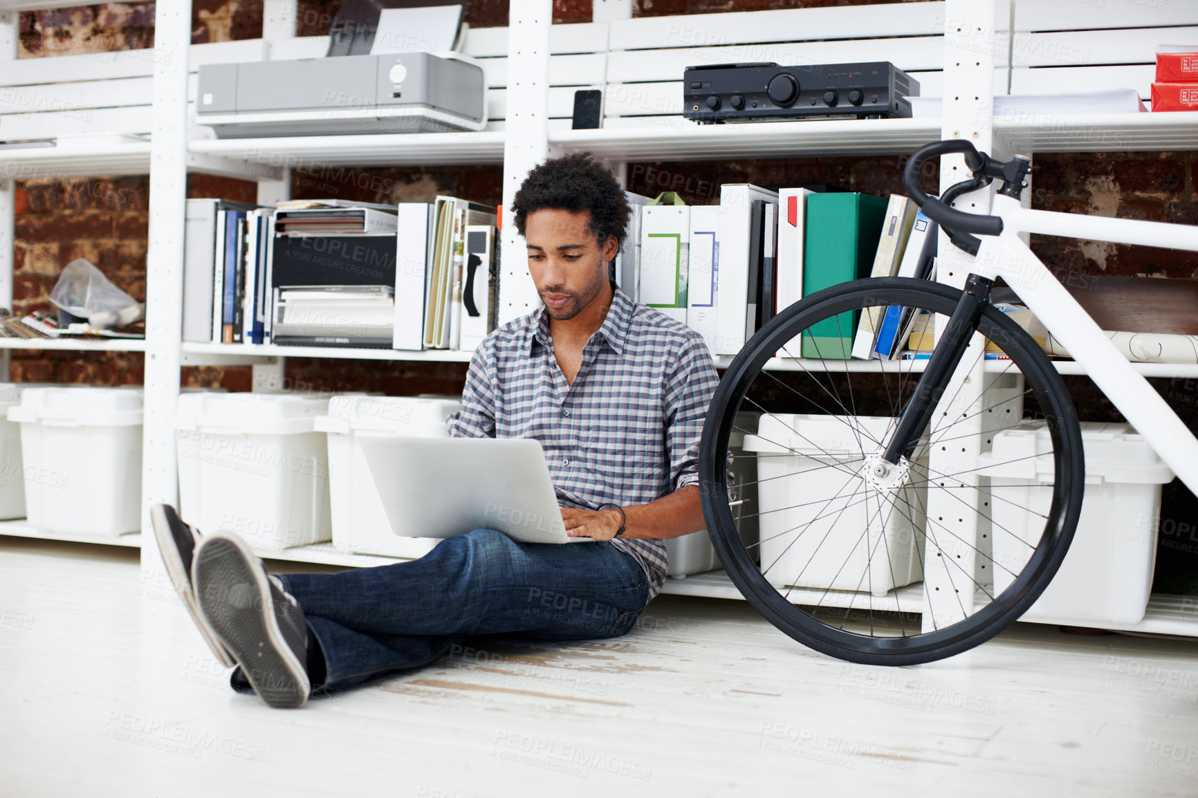 Buy stock photo Laptop, bicycle and black man on floor in office for copywriting, online article and story draft. Creative, startup and person on computer for research, website blog and report with bike in workplace