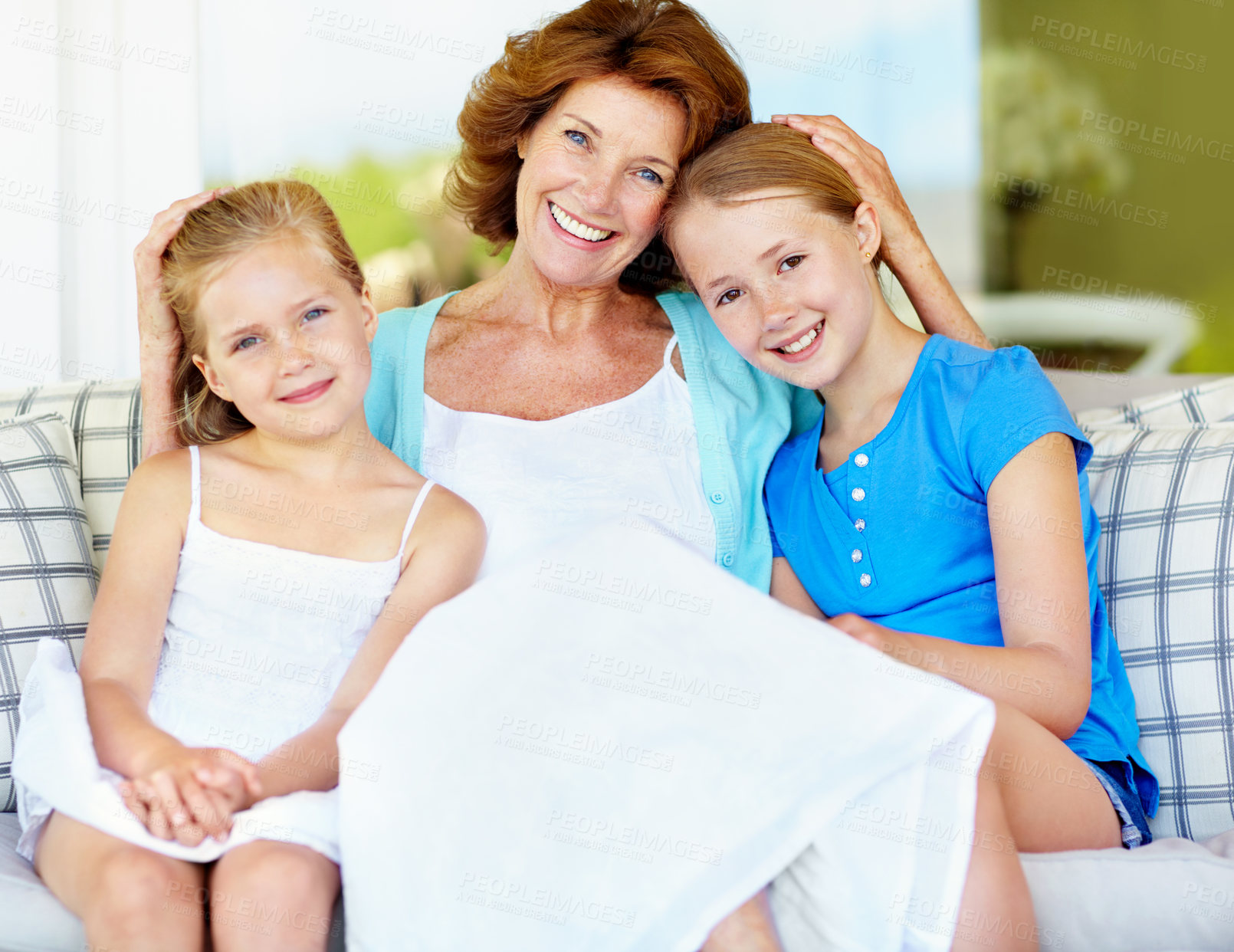 Buy stock photo Grandmother, smile and children with love on sofa, relax and bonding together on weekend break. Grandma, sisters and care on couch at home, grandkids and hug with family portrait in living room
