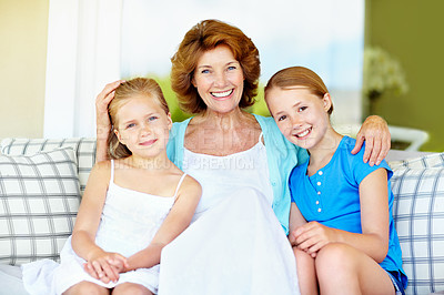 Buy stock photo Portrait, grandmother and girl children in living room, bonding and family love with care on couch. Smile, connection and old woman with grandchildren, trust and relationship with relax at home