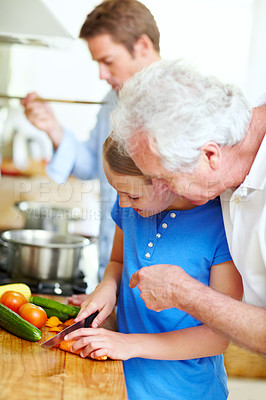 Buy stock photo Cooking, cutting and help with child and grandfather in kitchen for learning, lunch and food. Love, vegetables and teaching with old man and granddaughter in family home for wellness and support