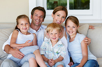 Buy stock photo Portrait, home and parents with children on couch, love and family with smile on break and together. Happy people, bonding and connection with kids on weekend, mother and father at house in Germany