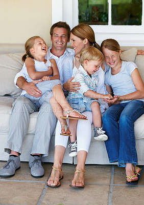 Buy stock photo Happy, relax and children with parents on sofa in home for bonding, love and connection on weekend. Laugh, calm and kids with mother and father on couch in living room for family and care in house.