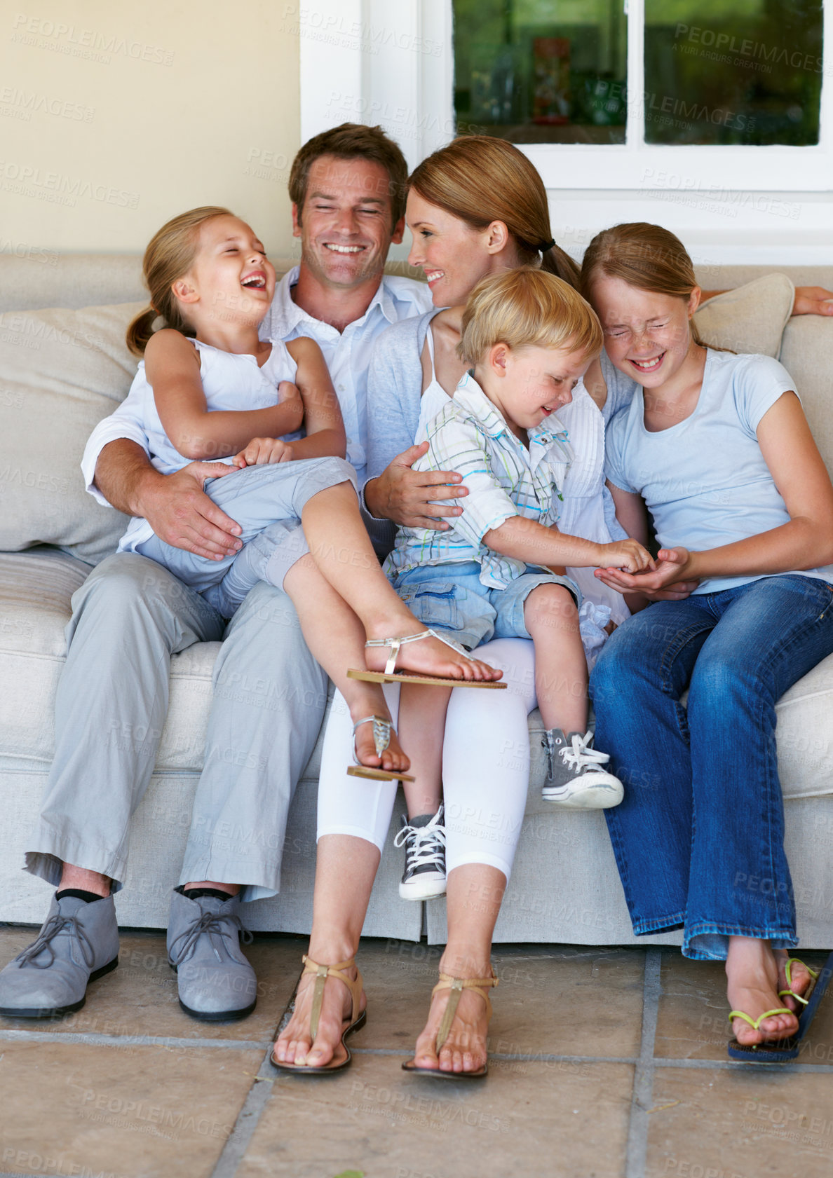 Buy stock photo Happy, relax and children with parents on sofa in home for bonding, love and connection on weekend. Laugh, calm and kids with mother and father on couch in living room for family and care in house.