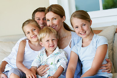 Buy stock photo Happy, portrait and parents with children on sofa for bonding together, healthy relationship or care. Smile, family and girls with love in home for connection, security and weekend break with support