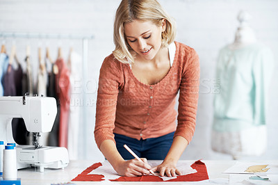 Buy stock photo A beautiful young tailor drawing the outline of a pattern for a garment