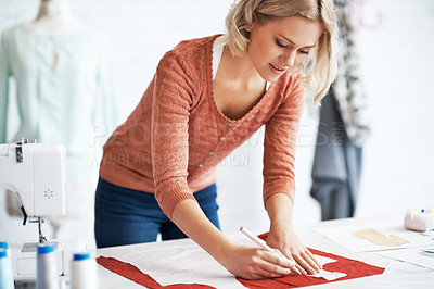 Buy stock photo A beautiful young tailor drawing the outline of a pattern for a garment