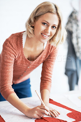 Buy stock photo Portrait of a beautiful young tailor drawing the outline of a pattern for a garment