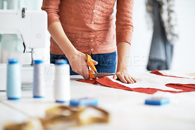 Buy stock photo Cropped image of a tailor cutting material for a garment 