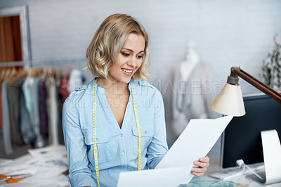 Buy stock photo A beautiful young tailor looking at designs
