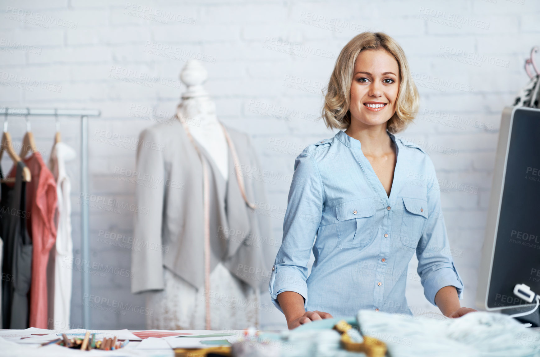 Buy stock photo A gorgeous young designer working on her computer while smiling at the camera