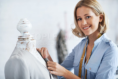 Buy stock photo A young tailor working on a design while smiling at the camera