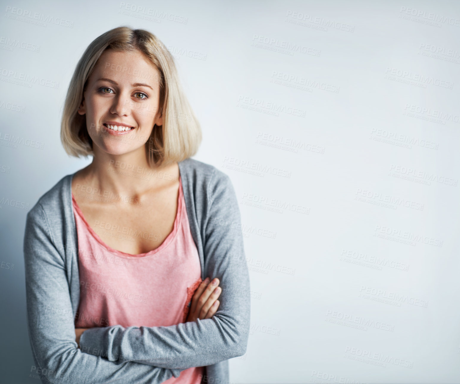 Buy stock photo Portrait of a pretty young blonde woman leaning against a white wall