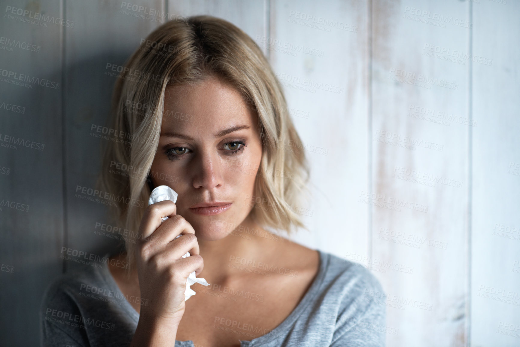 Buy stock photo Sad, crying and woman with tissue in home for overthinking, emotional crisis and loss. Wall, reflection and person with depression, tears and overwhelmed for trauma, grief and lonely for breakup
