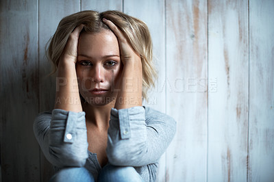 Buy stock photo Portrait of a tearful young woman with her hand in her hair