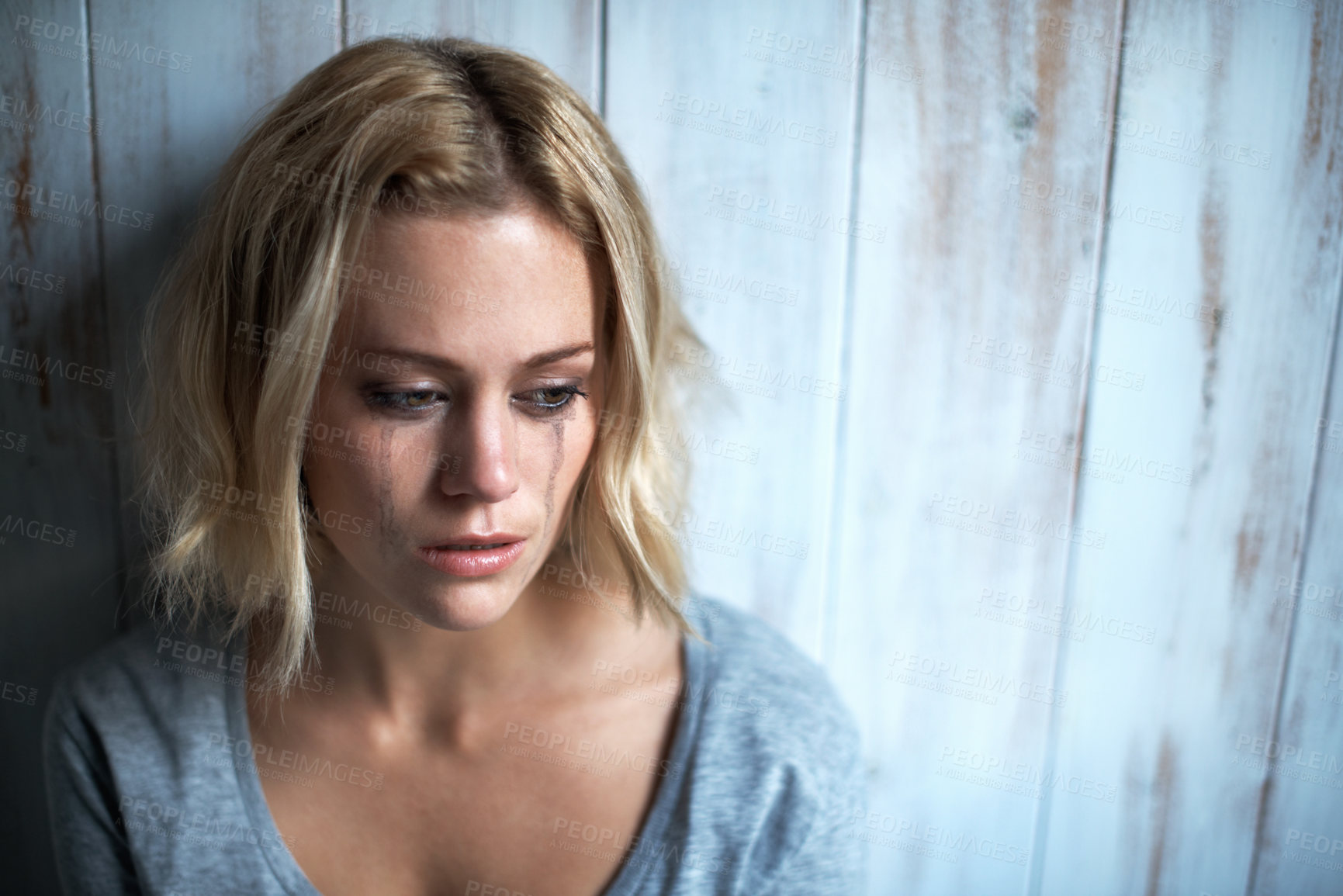 Buy stock photo High-angle view of a young woman with mascara tears running down her face
