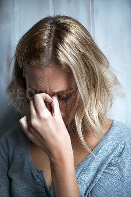 Buy stock photo A young woman with her hand over her face crying