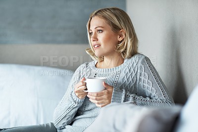 Buy stock photo A pretty young blonde woman sitting at home and enjoying a cup of coffee