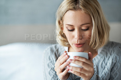 Buy stock photo A closeup of a young blonde woman blowing on a cup of hot coffee