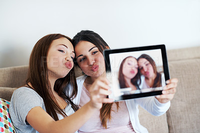 Buy stock photo Two teenage girls taking a self portrait on their tablet at home
