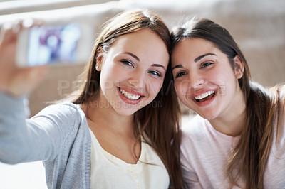 Buy stock photo Two teenagers taking a picture of themselves on a phone