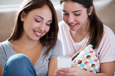 Buy stock photo Two teenagers looking at a text message on a cellphone