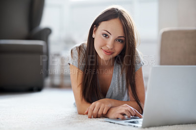 Buy stock photo Portrait of a gorgeous teenager working on her laptop while lying on the floor