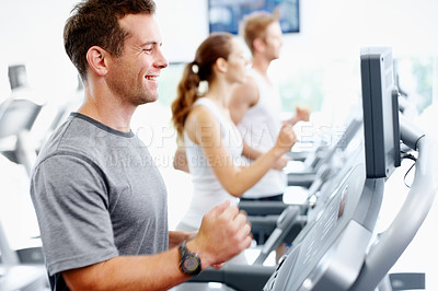 Buy stock photo Smiling man running on a treadmill in his local gym