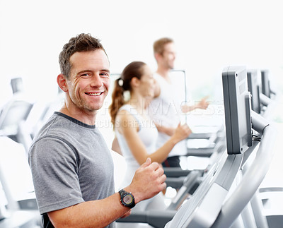 Buy stock photo Happy man running on a treadmill in his local gym