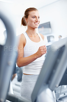 Buy stock photo Motivated young woman jogging on a treadmill at the gym