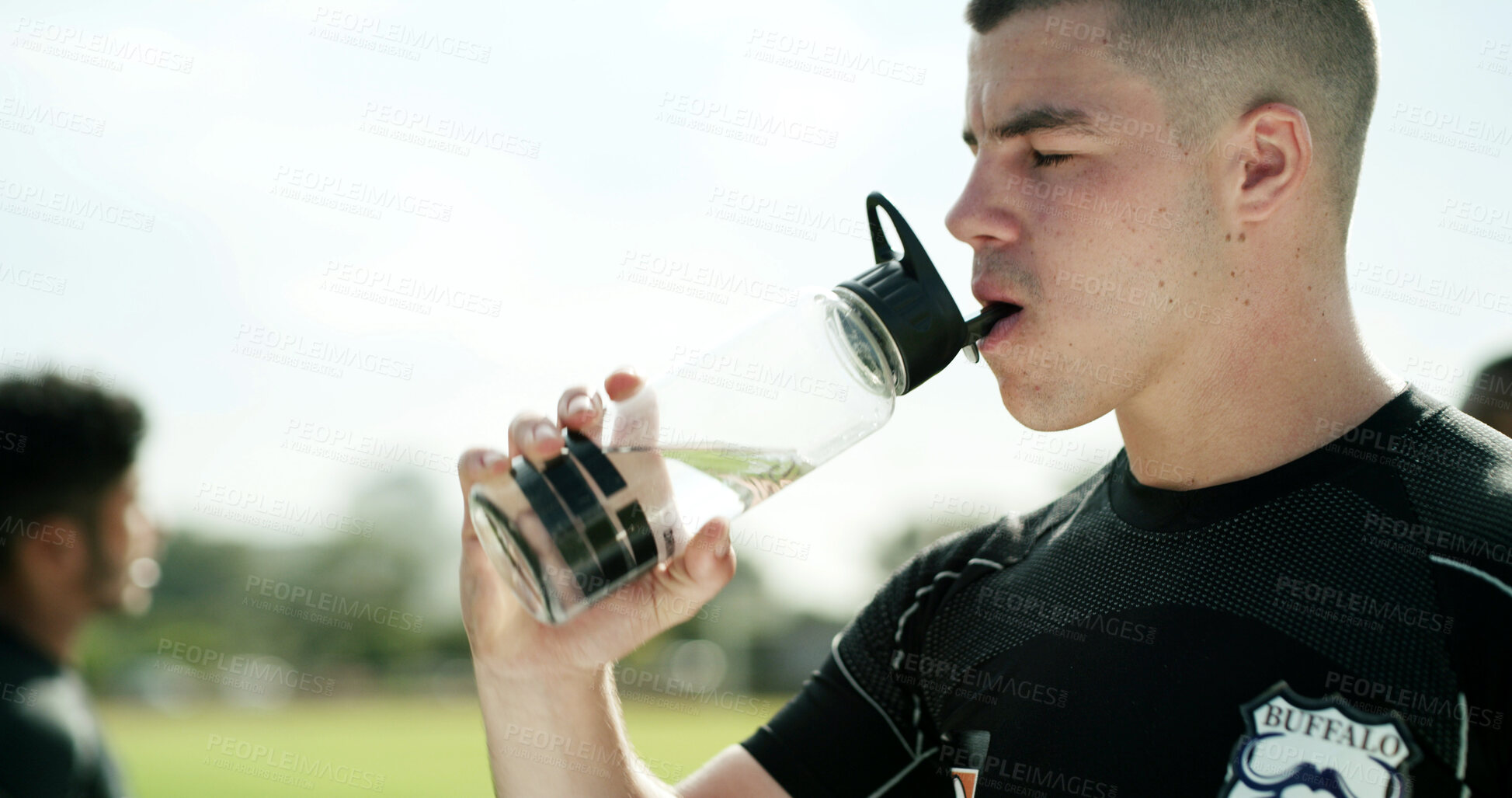 Buy stock photo Rugby, man or drinking water for fitness outdoor, wellness and electrolytes on workout break. Hydration, sports athlete and person with bottle after exercise, health and resting for training recovery